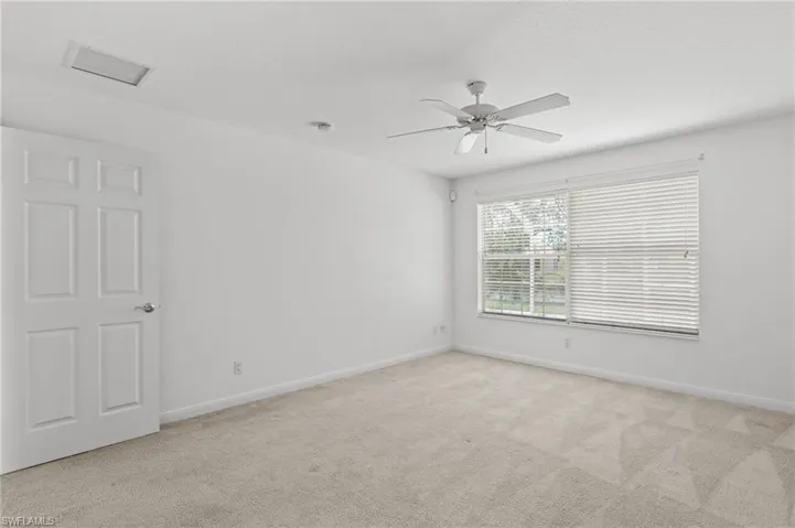 Carpeted empty room featuring ceiling fan