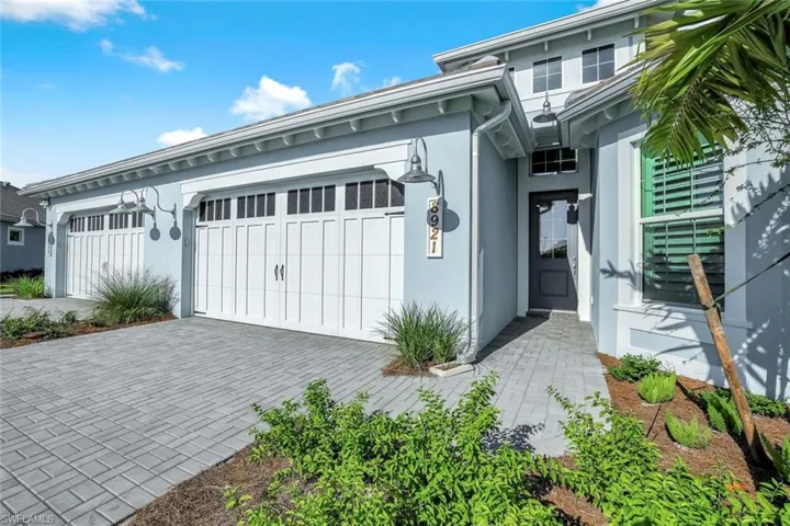View of front facade featuring stucco siding, decorative driveway, and a garage