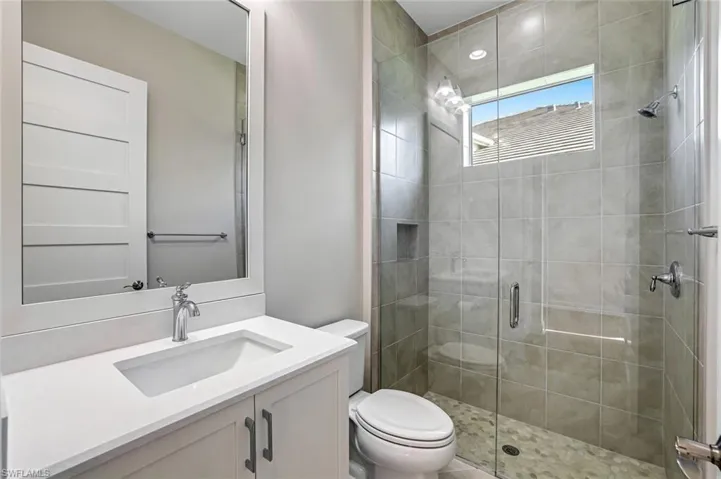 Bathroom featuring a shower stall and vanity