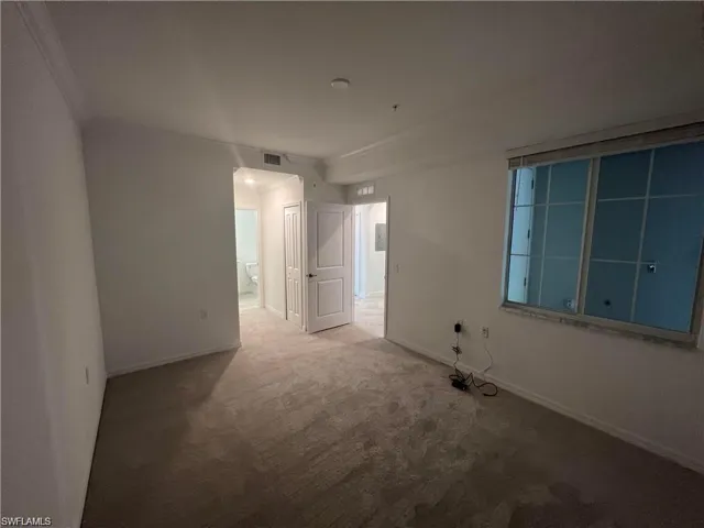 Carpeted empty room featuring baseboards