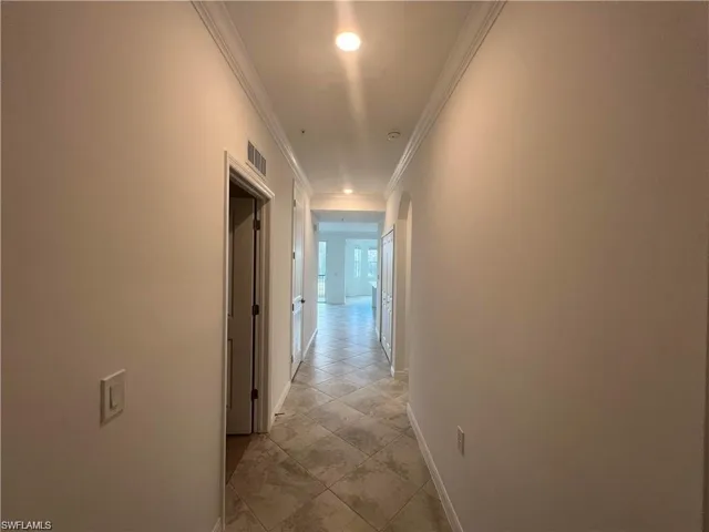 Hallway with baseboards, recessed lighting, and ornamental molding