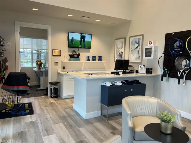 Racquet Club featuring light countertops, light wood-type flooring, white cabinets, recessed lighting, and baseboards