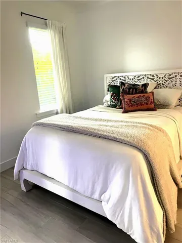 Bedroom with wood finished floors and baseboards