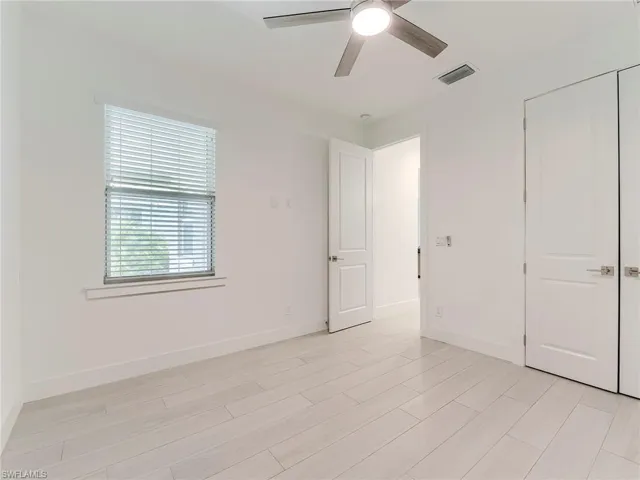 Unfurnished bedroom with ceiling fan and wood tiled floors