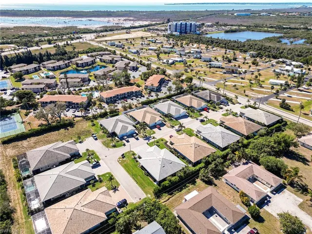Aerial view of property and surrounding area with a large body of water and nearby suburban area