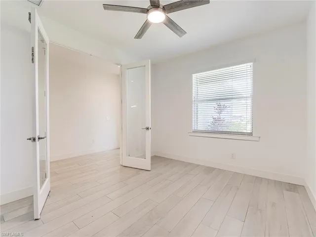Spare room featuring french doors, light wood-style floors, and ceiling fan