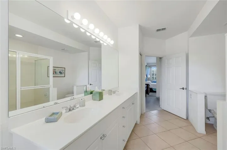 En suite primary bathroom with dual vanities, a separate shower and a soaking tub.