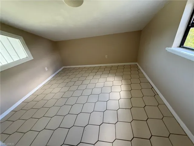 Room featuring hexagonal floor tile, dual windows, and light-toned walls