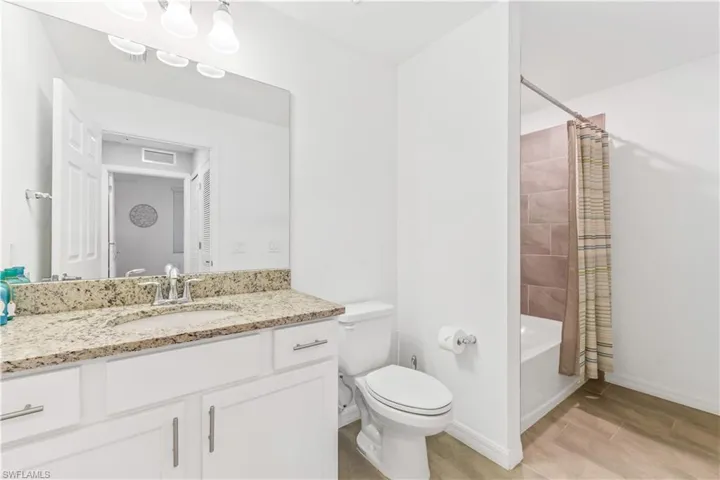 Full bathroom with vanity, toilet, tile floors, and shower / tub combo