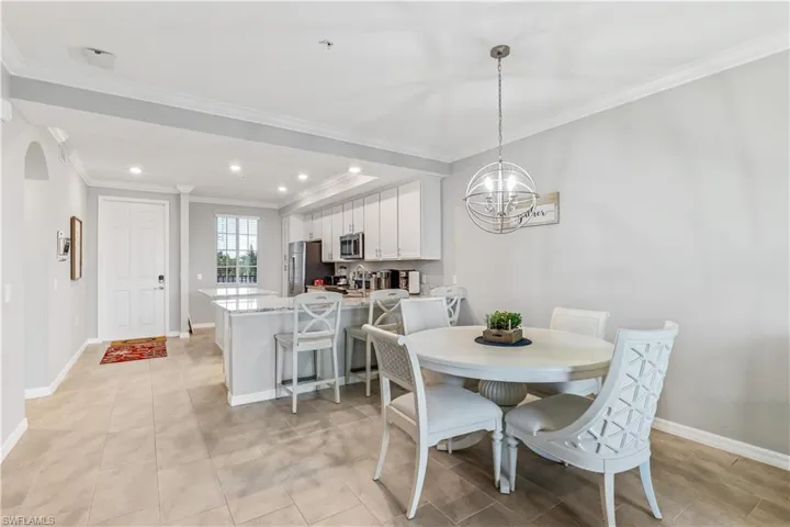 Dining area featuring a chandelier, light tile floors, and crown molding