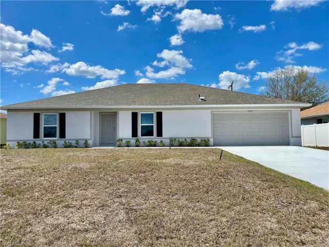 Ranch-style home with stucco siding, an attached garage, a shingled roof, and driveway