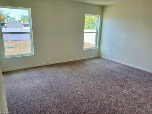 Carpeted empty room with baseboards