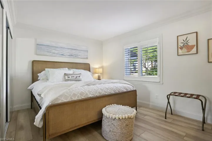 Bedroom featuring ornamental molding and hardwood / wood-style flooring