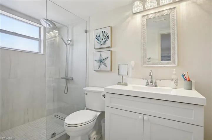 Bathroom featuring oversized vanity, toilet, and walk in shower