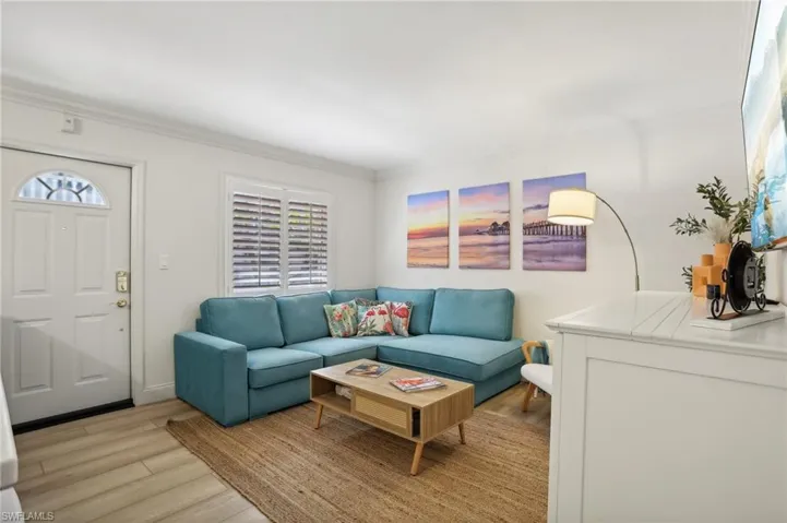 Living room featuring ornamental molding and light wood-type flooring