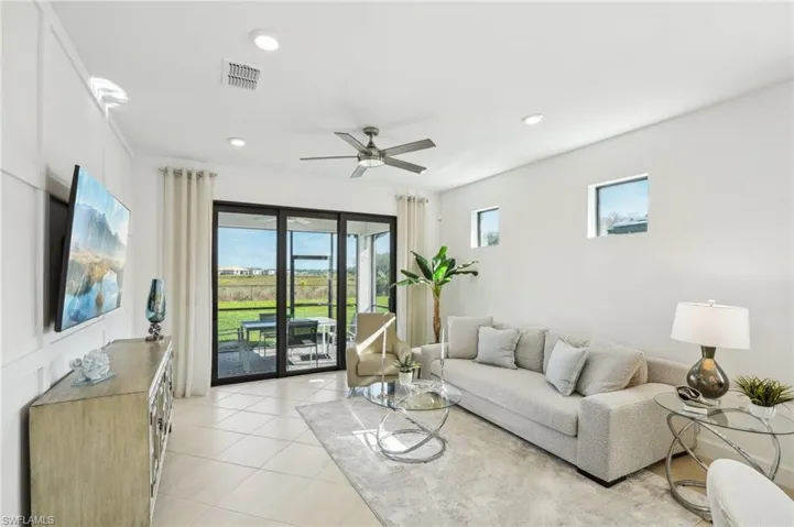 Tiled living room featuring plenty of natural light and ceiling fan
