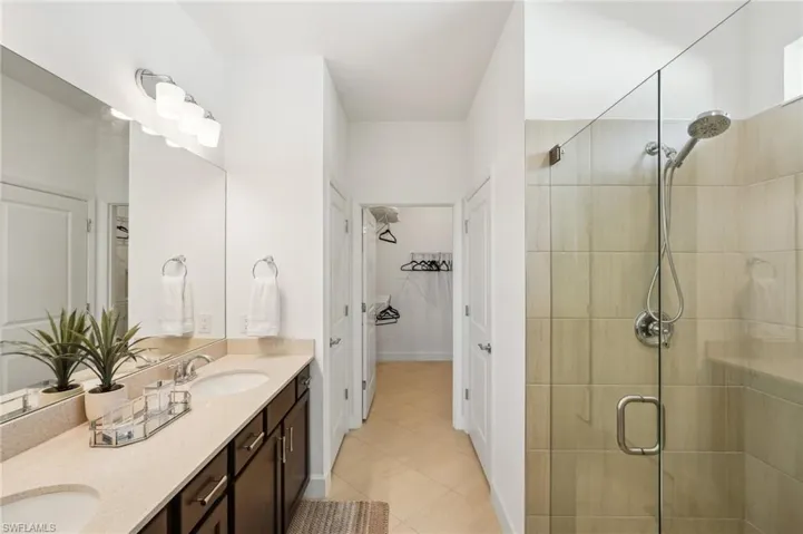 Bathroom with vanity, tile patterned floors, and a shower with door