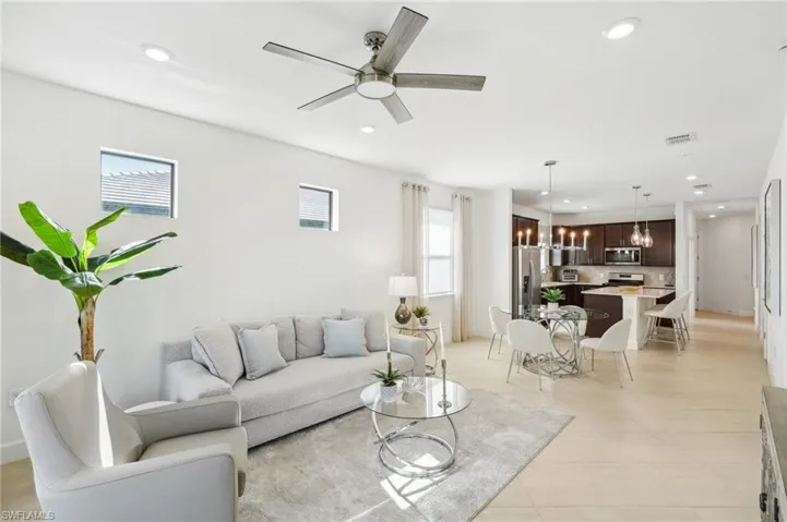 Living room with ceiling fan with notable chandelier