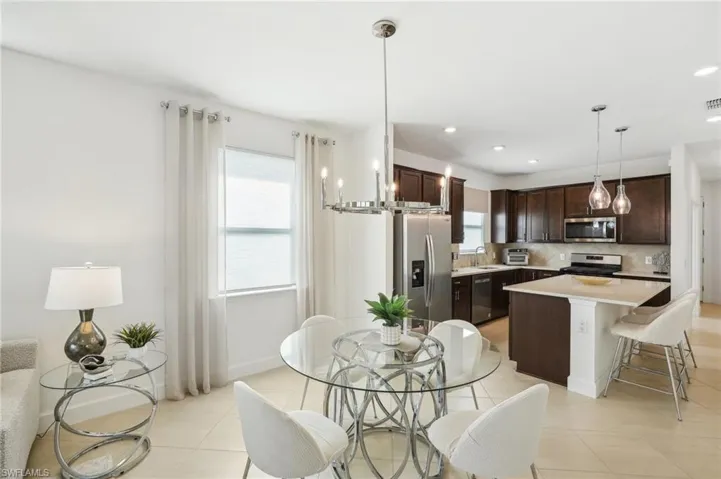 Tiled dining room with sink and a chandelier