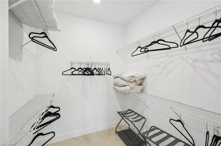 Spacious closet with light tile patterned floors