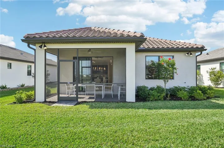 Back of property with a sunroom, a patio area, and a yard