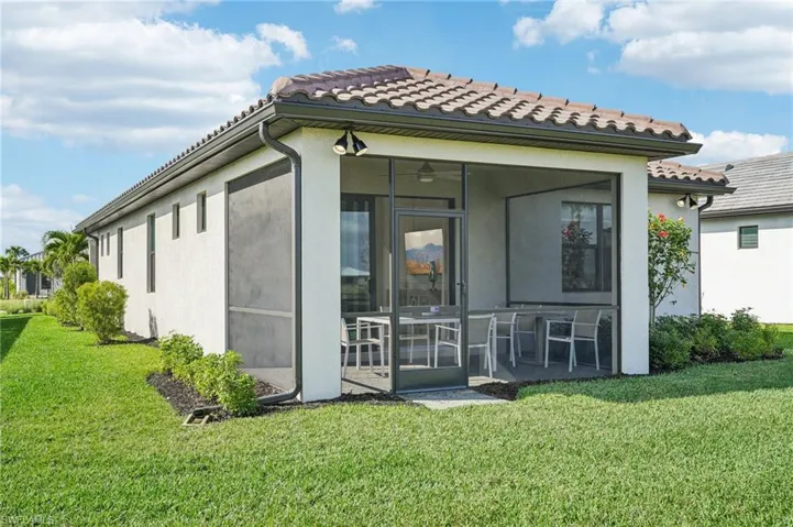 Rear view of property featuring a lawn and a sunroom