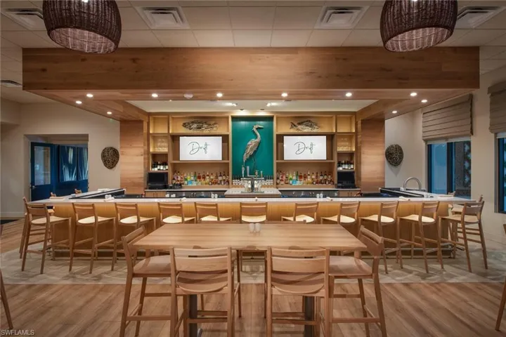 Bar featuring beam ceiling and light wood-type flooring