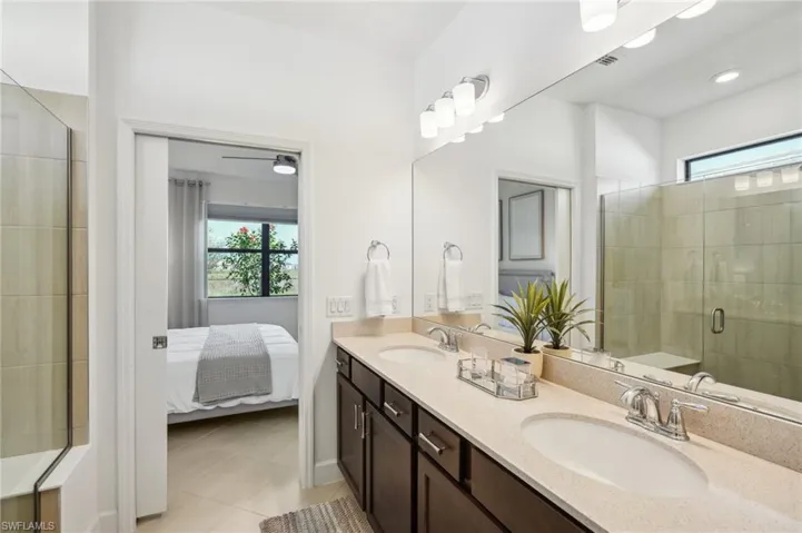 Bathroom featuring tile patterned flooring, vanity, and walk in shower