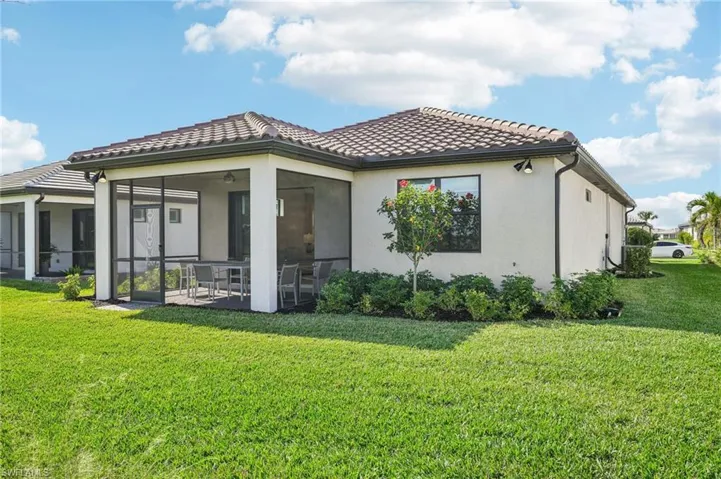 Rear view of house with a yard and a sunroom