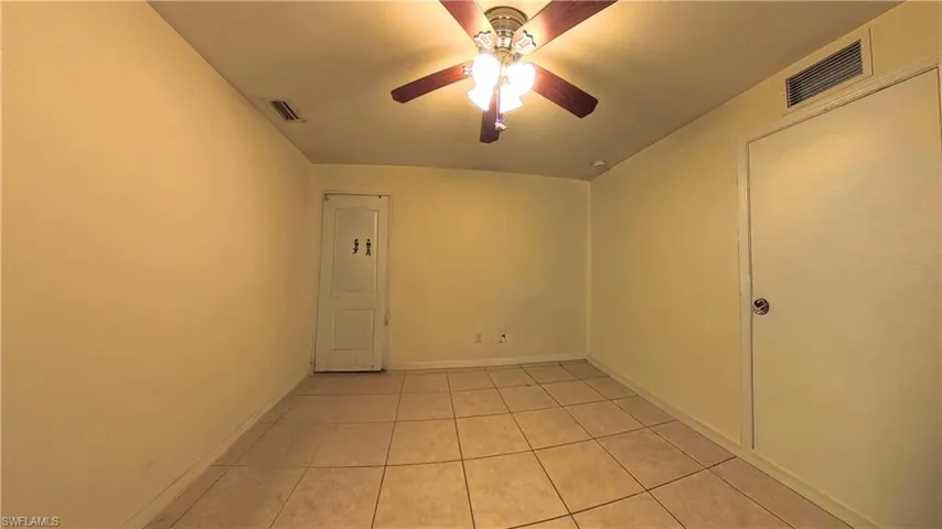 Spare room featuring light tile patterned floors and ceiling fan