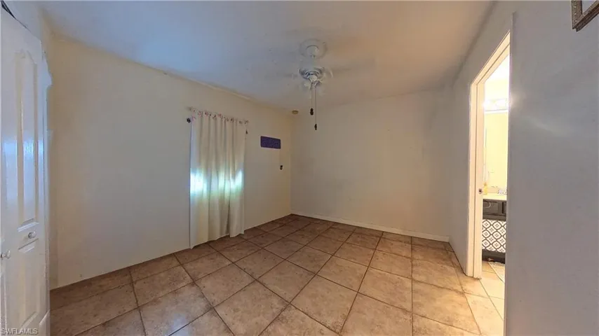 Spare room with a ceiling fan and light tile patterned flooring