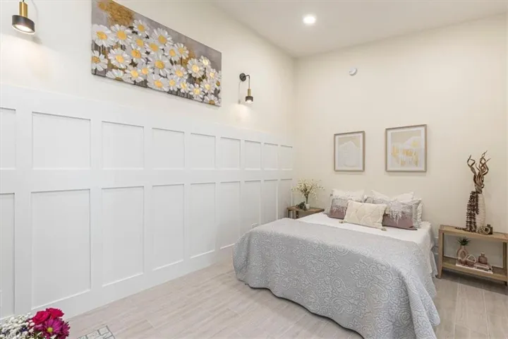 Bedroom with wood tiled floors, recessed lighting, and a decorative wall