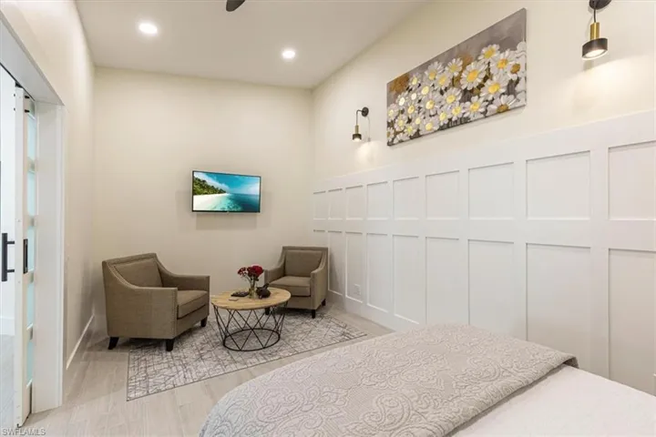 Bedroom with a decorative wall, recessed lighting, a ceiling fan, and wood finished floors