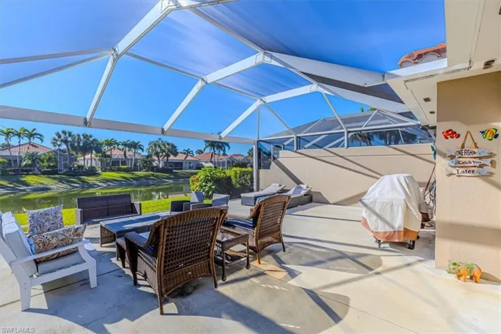 View of patio / terrace with a water view, a sunroom, a lanai, an outdoor living space, and grilling area
