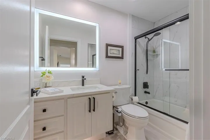 Bathroom with enclosed tub / shower combo and vanity