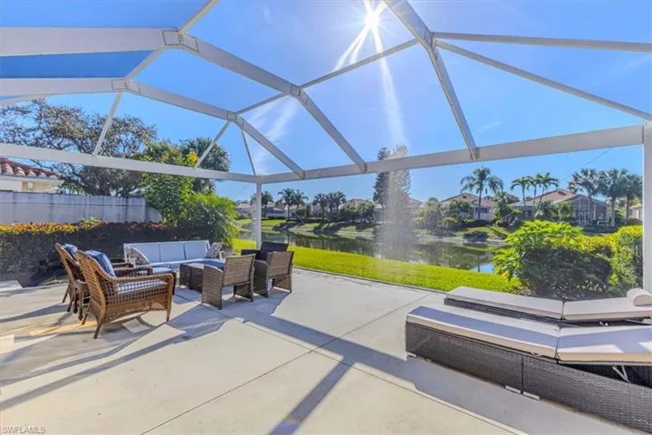 View of patio with outdoor lounge area, a water view, glass enclosure, and a sunroom