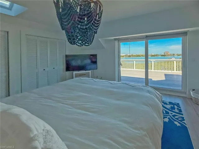 Bedroom featuring a closet, hardwood / wood-style floors, access to exterior, and a skylight