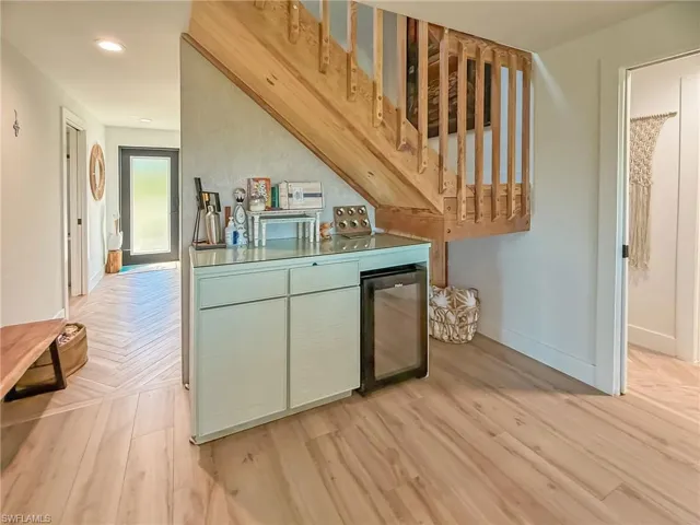 Kitchen with beverage cooler and light parquet floors