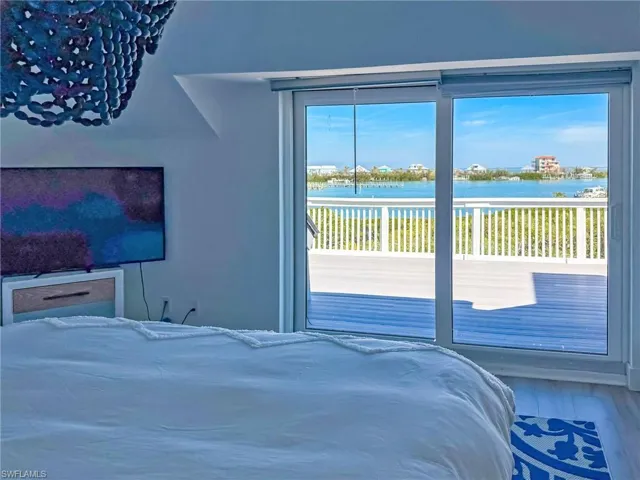 Bedroom featuring a water view, wood-type flooring, and access to outside