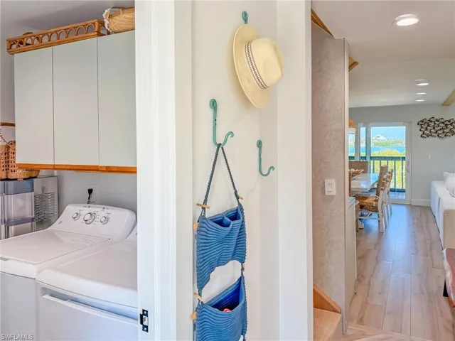 Washroom featuring cabinets, independent washer and dryer, and light hardwood / wood-style floors