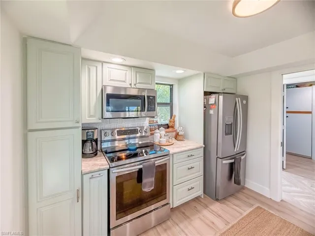 Kitchen featuring stainless steel appliances, light hardwood / wood-style floors, and decorative backsplash
