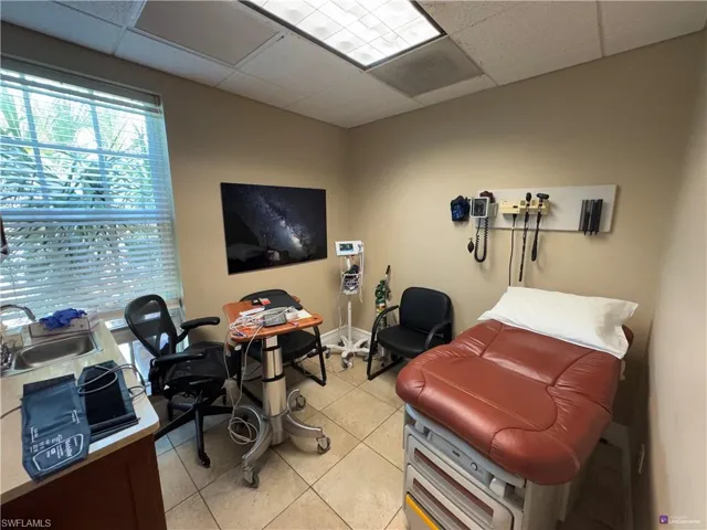 Tiled office space with a drop ceiling and sink