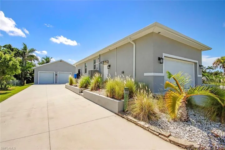 View of property exterior with stucco siding, an outbuilding, and a garage