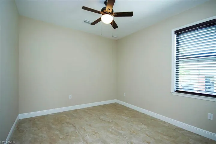 Empty room featuring baseboards and a ceiling fan