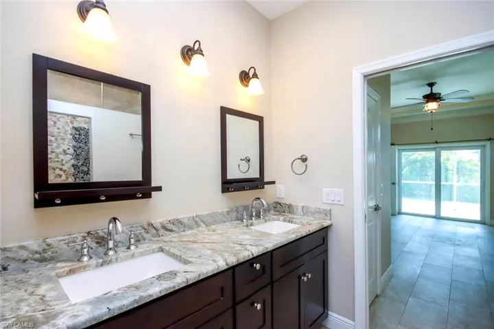 Bathroom with double vanity and a ceiling fan