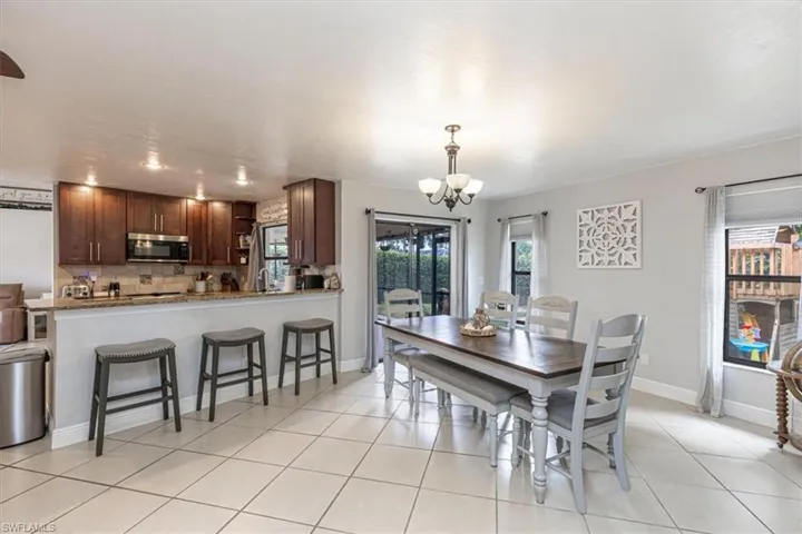 Dining room with a chandelier and light tile patterned flooring
