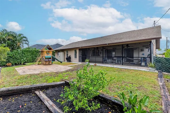 Back of house featuring a yard, ceiling fan, a playground, and a sunroom