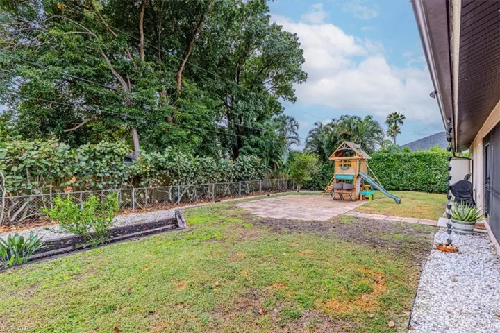 Fenced backyard with a patio and a playground