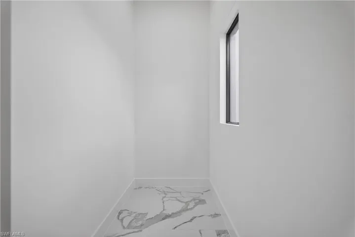 Full bath featuring a marble finish shower, vanity, light marble finish floors, and recessed lighting