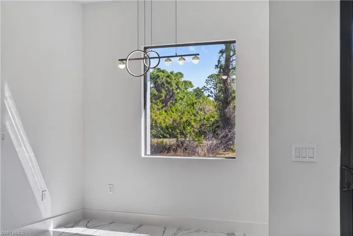 Unfurnished dining area with baseboards and suspended lighting